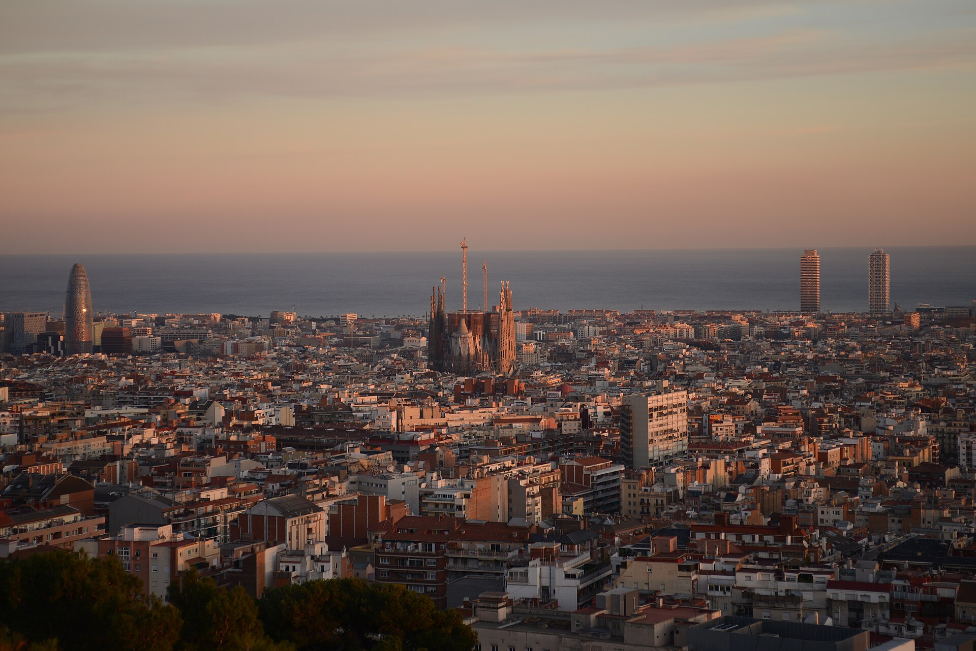 Barcelona at sunset seen from Park Güell, with the Sagrada Família and the sea