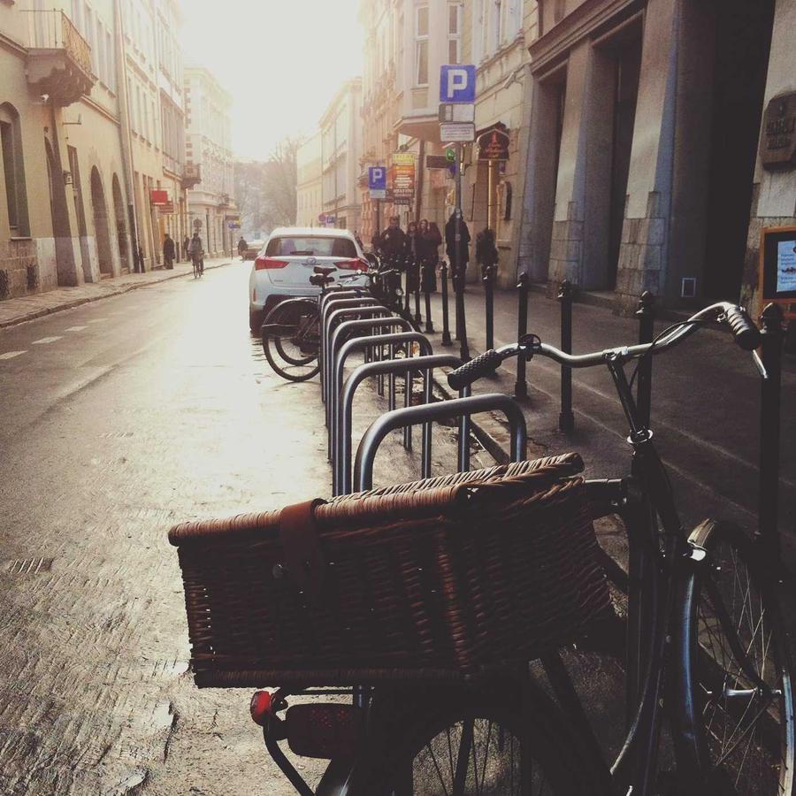 Bicycle with a basket outside a café on a wet street